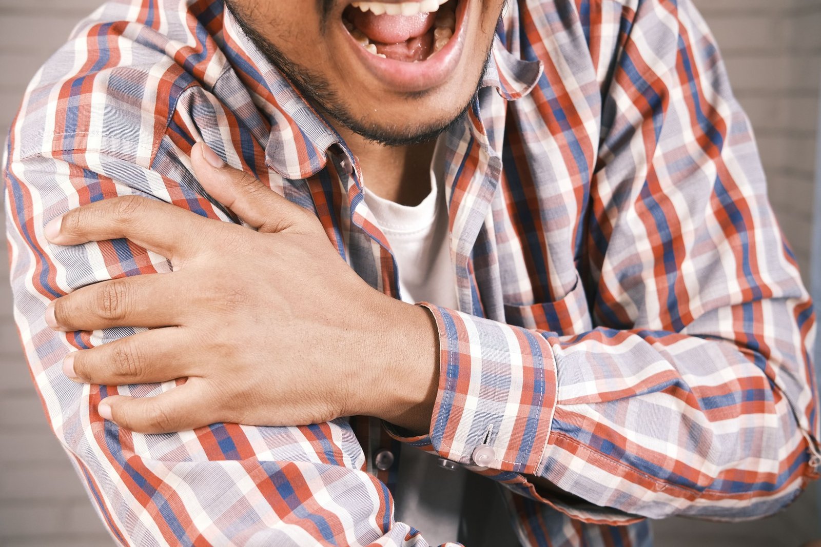 An arm held across the body in low light
