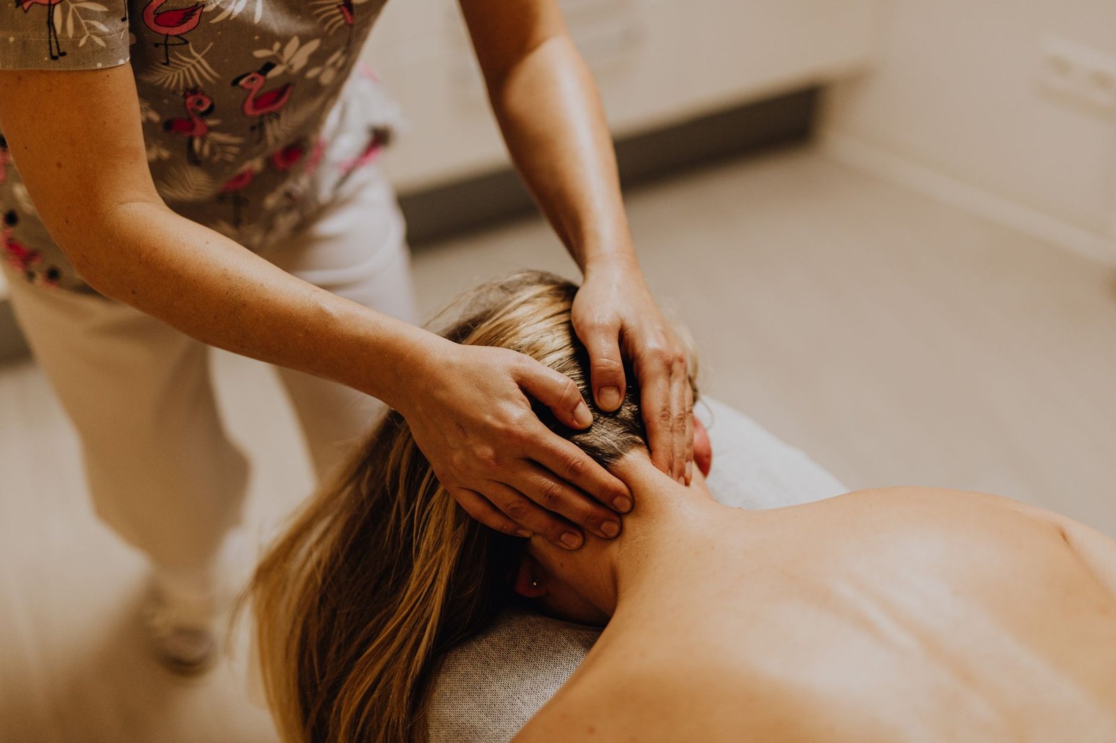 A therapist palpating the neck and shoulder muscles to locate a trigger point